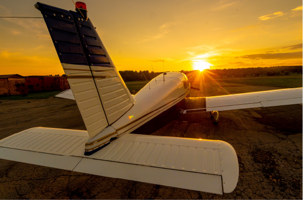 private plane on runway viewed from the tail at sunset