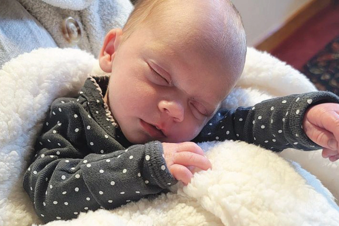 happily sleeping baby in mothers arms