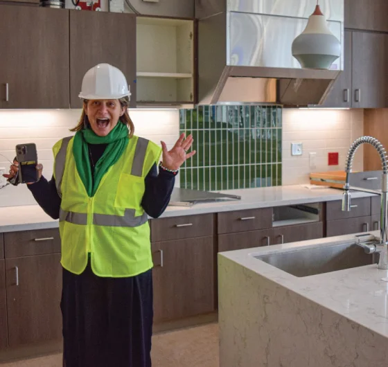 director in safety gear visiting future kitchen location while under construction